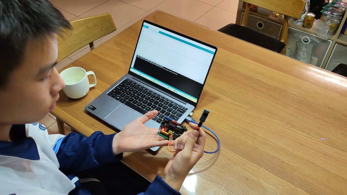 Holding the assembled controller board next to a laptop running the acquisition code.