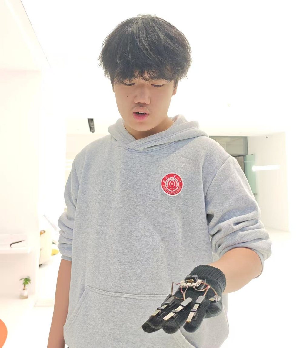 Wearing the glove prototype, with the sensor board and wiring mounted on the back of the hand.